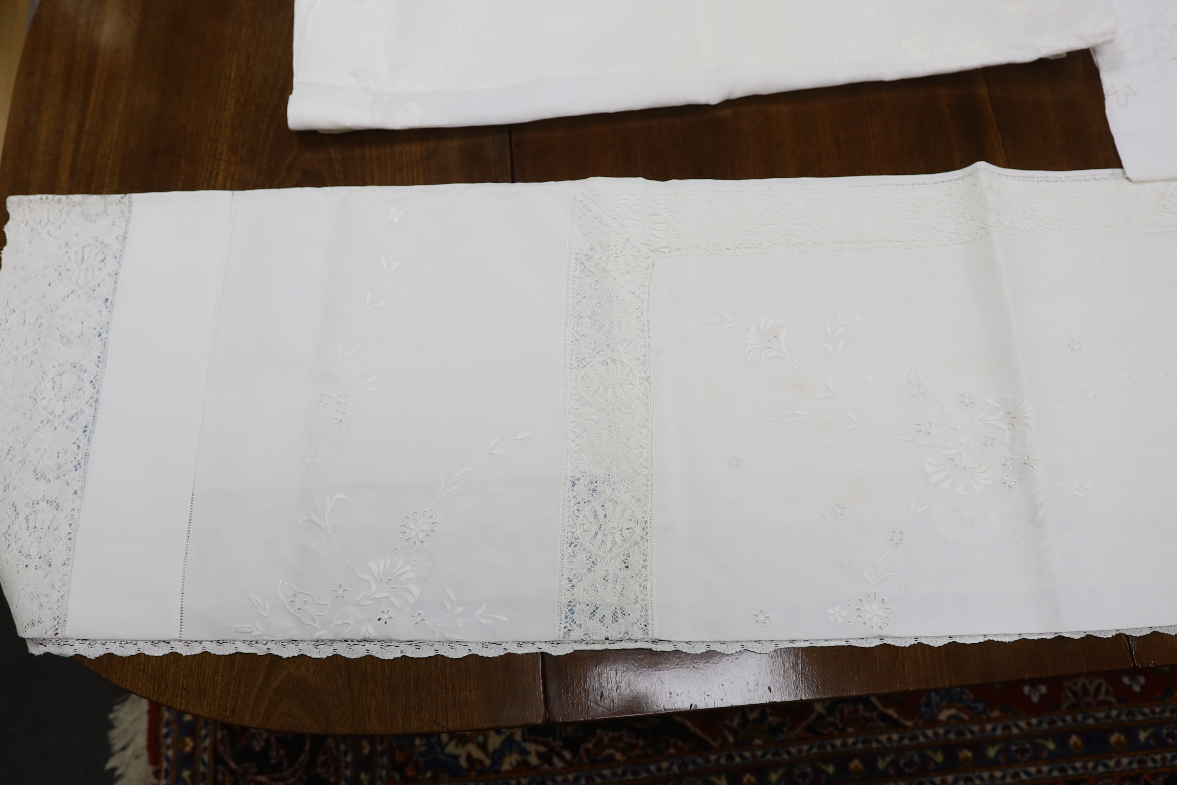 Table linen; A large linen embroidered and finely worked table cloth, an Anglaise worked cloth with crochet border and a fine appliqué cloth (3)